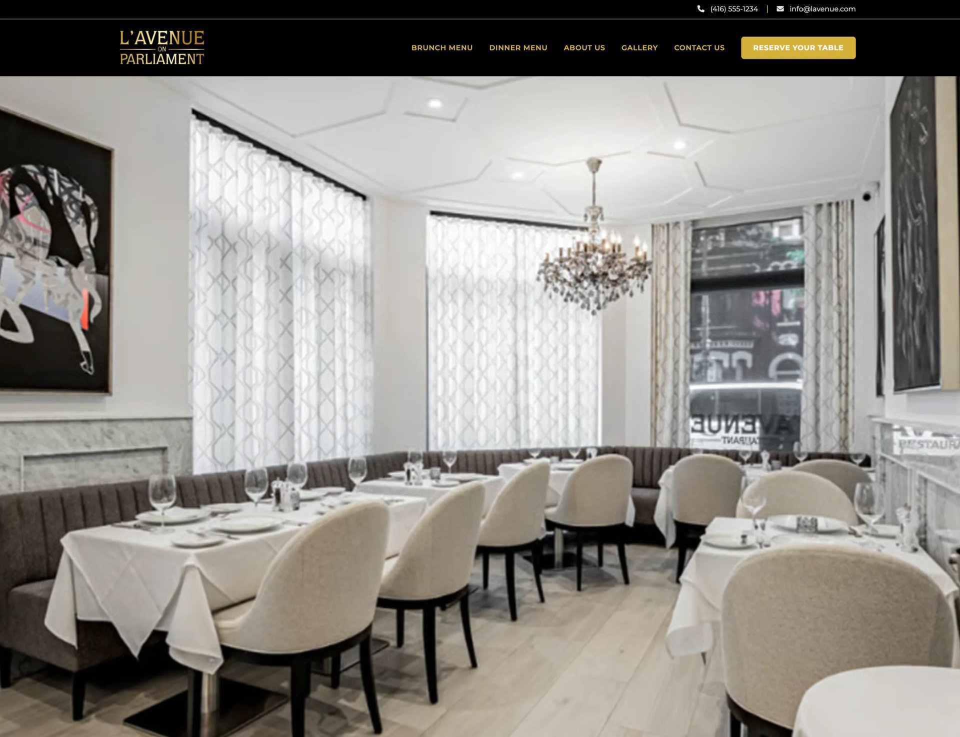 Modern upscale restaurant dining room with cream chairs, white tablecloths, crystal chandelier, and large windows with patterned curtains