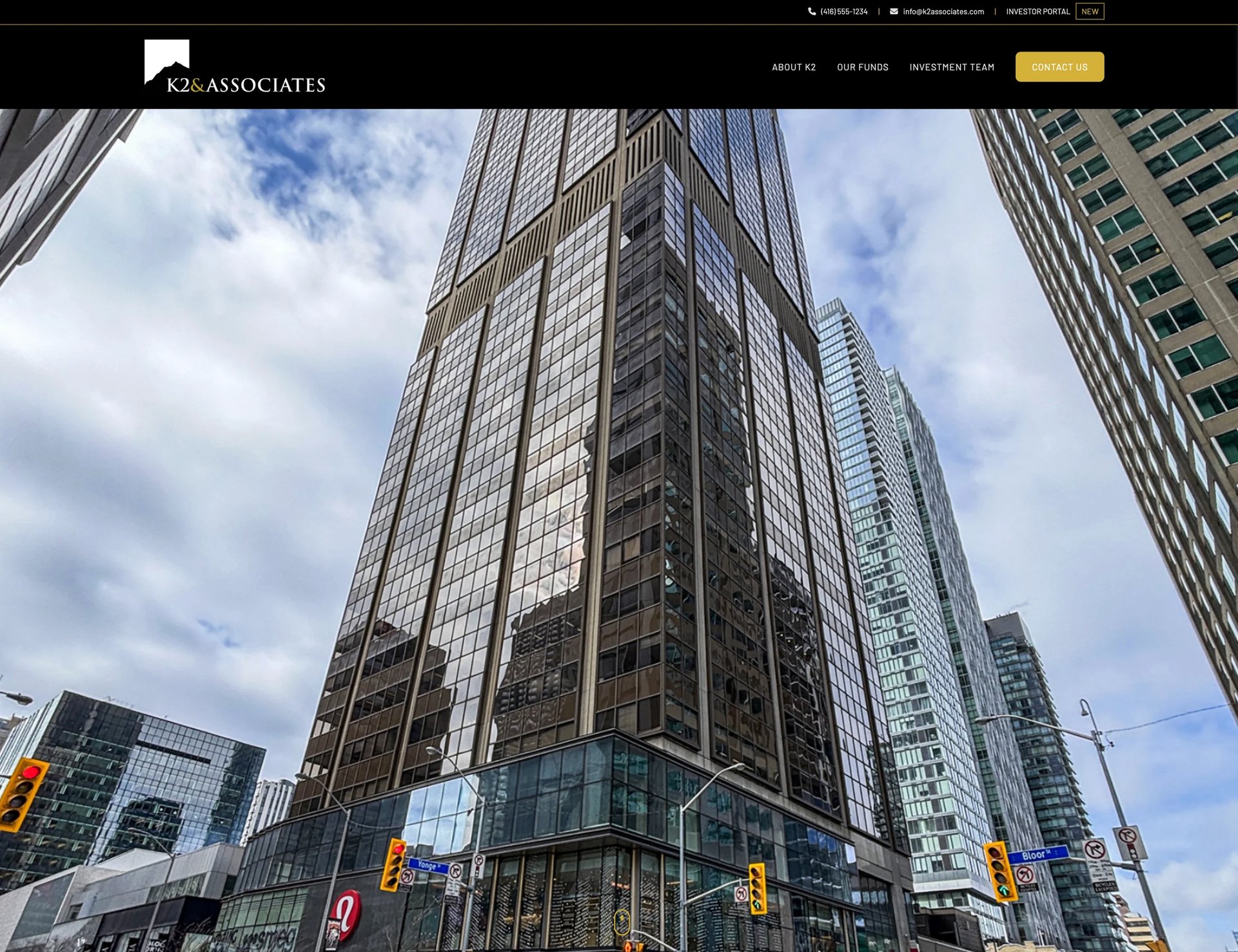 Modern downtown skyscraper with glass and steel facade surrounded by other tall buildings against a cloudy sky