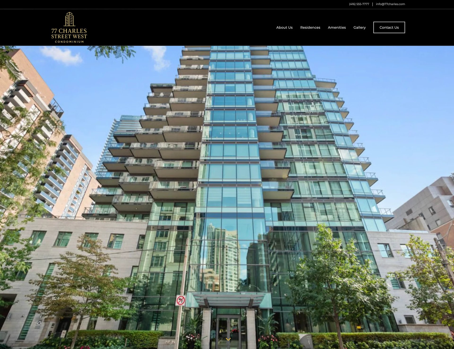 Modern glass and metal residential high-rise tower with tiered balconies surrounded by older brick buildings and green foliage