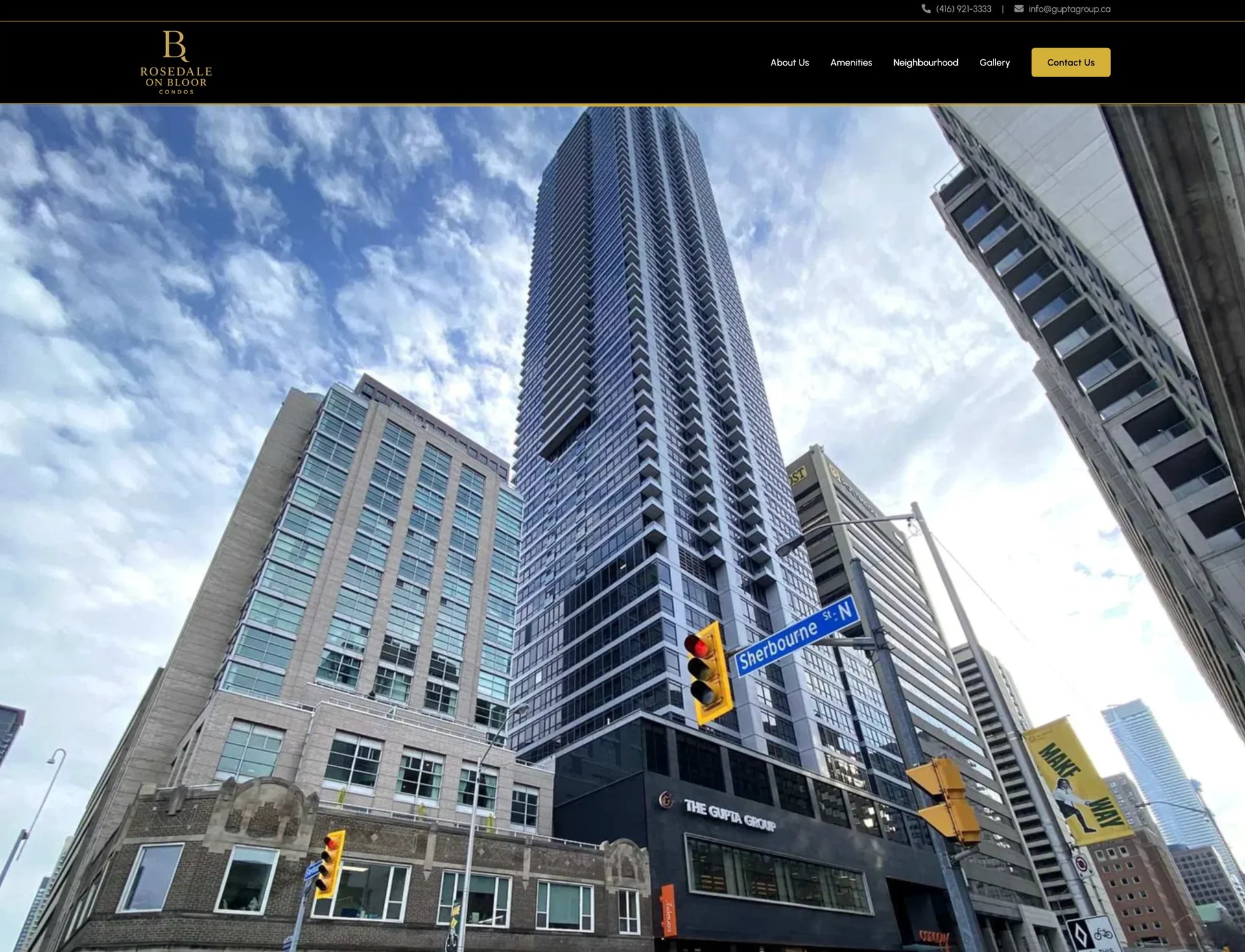 Upward view of modern downtown high-rise buildings with a tall residential tower in the center against a blue sky with clouds
