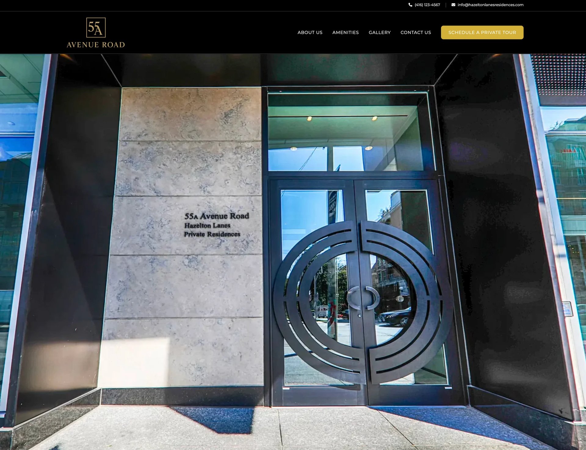 Modern building entrance at 55 Avenet Road with marble cladding, large circular metal door handles, and glass doors