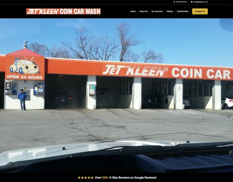 Jet Kleen Coin Car Wash exterior with orange and white storefront, multiple wash bays, and clear daytime sky